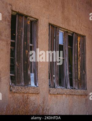 Zwei kaputte Fenster in einem verlassenen Geschäft in einem Gebäude in Colorado Stockfoto