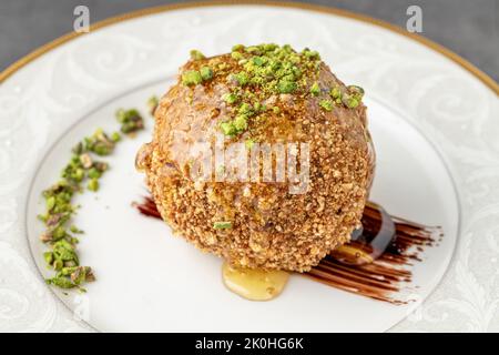 Gebratenes Eis mit Erdnüssen auf einem weißen Porzellanteller Stockfoto