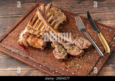 Gegrillte Lammkoteletts auf einem hölzernen Servierteller Stockfoto