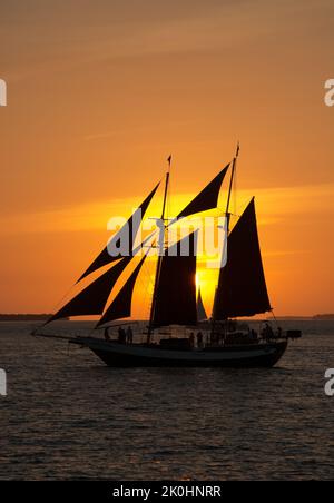 Eine vertikale Aufnahme eines Piratenschiffs, das bei Sonnenuntergang in der Nähe von Key West, Florida, auf dem Wasser segelt Stockfoto