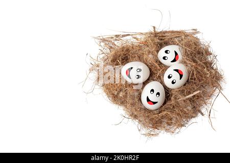 Eine Draufsicht auf Eier mit Smiley-Gesichtern auf einem Nest, isoliert auf weißem Hintergrund Stockfoto