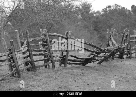 Eine Graustufenaufnahme des alten gebrochenen Holzzauns. Stockfoto