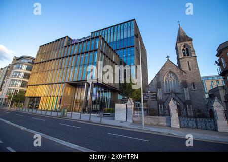 Das Büro des Grant Thorton Hauptquartiers in Dublin, Irland, mit der Immaculate Heart of Mary Church neben der Kirche Stockfoto