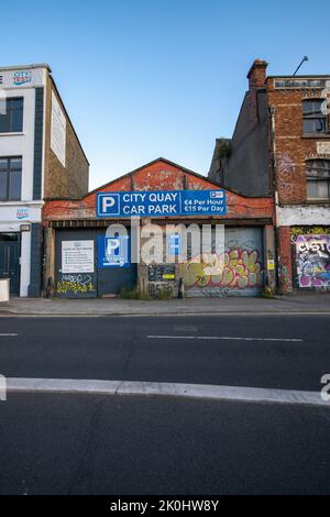 Ein schöner Blick auf ein altes Gebäude mit Graffiti-Kunst und Parkplatz Stockfoto