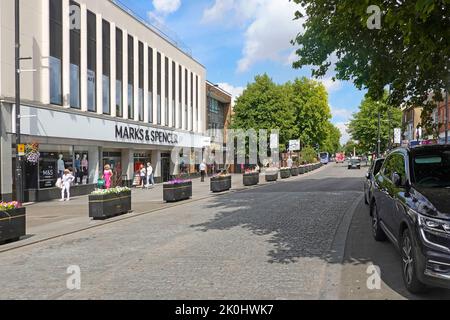 Brentwood, gepflasterte Einkaufsstraße, High Street mit Marks & Spencer, Café-Gebäude, façade Sommer-Blumenkästen und Parkplatz auf der Straße, Essex England, Großbritannien Stockfoto