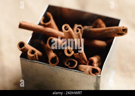 cassia Zimtstangen in einer metallischen Schachtel Stockfoto