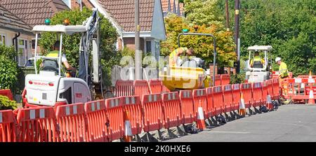 Arbeiter & Aushub Dumper Maschinen arbeiten Wohn geschlossenen Gehweg footway Graben für Glasfaser-Breitband-Kabel-Infrastruktur England Großbritannien Stockfoto