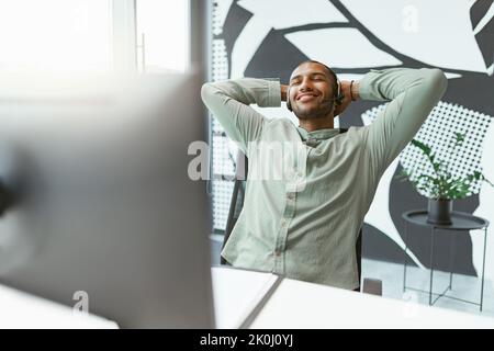Glückliche afrikanische Geschäftsmann haben eine Pause nach der Arbeit am Computer im Büro Stockfoto