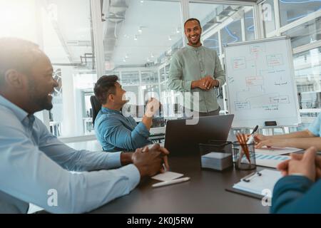 Ein männlicher Business-Coach oder Sprecher präsentiert bei Meetings den verschiedensten Geschäftsleuten Flipchart-Präsentationen Stockfoto