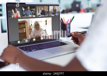 Hände einer afroamerikanischen Frau, die mit verschiedenen Kollegen einen Videoanruf auf einem Laptop führt und auf dem Bildschirm winkt. Geschäftskommunikation, Remote arbeiten und Zahlen Stockfoto