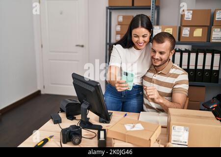 Männer und Frauen, die im Geschäft arbeiten, machen Selfies am Smartphone Stockfoto