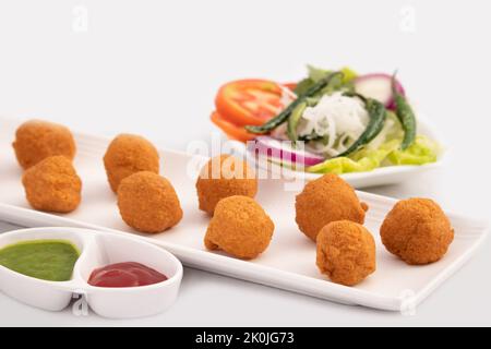 Indian Delhi Street Chaat Food Ram Laddu Pakode Oder Raam Ladoo Pakore Wird Aus Moong Dal, Yellow Mung Linsen, Chana Daal. Serviert Mit Weißem Radish Stockfoto