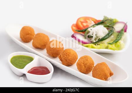 Indian Delhi Street Chaat Food Ram Laddu Pakode Oder Raam Ladoo Pakore Wird Aus Moong Dal, Yellow Mung Linsen, Chana Daal. Serviert Mit Weißem Radish Stockfoto