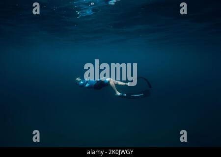 07. August 2021. Varna, Bulgarien. Männer gleiten mit Flossen auf tiefblauem Meer. Freitauchend unter Wasser in transparentem Meer Stockfoto