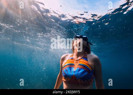 07. August 2021. Varna, Bulgarien. Attraktive Frau mit Flossen posiert unter Wasser im Ozean mit Sonnenlicht. Stockfoto