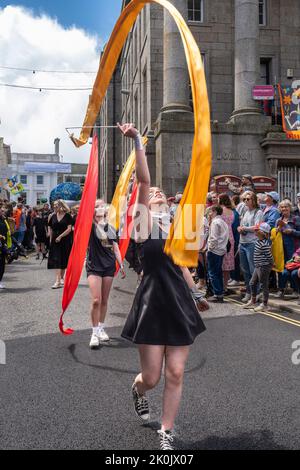 Schüler tanzen bei der Parade zum Mazey Day im Rahmen des Golowan Festivals in Penzance in Cornwall, Großbritannien. Stockfoto