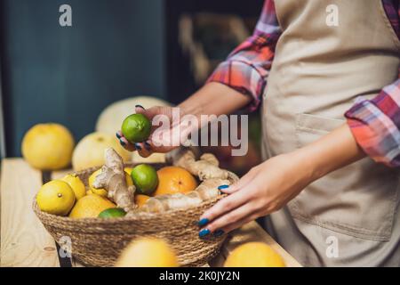 Frau arbeitet im Obst- und Gemüseladen. Sie stapelt Waren im Schaufenster. Stockfoto