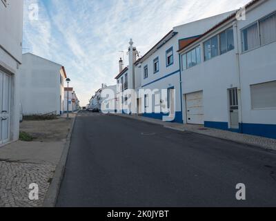 Porto Covo, Alentejo, Portugal, 25. Oktober 2021: Leere Straße mit portugiesischen blau-weißen Häusern in der historischen Stadt Porto Covo Stockfoto