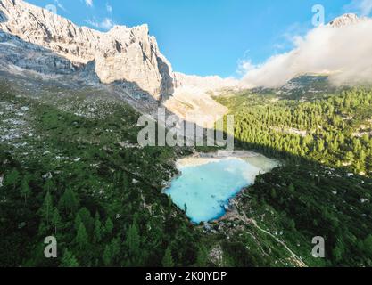 Blick von oben, herrlicher Panoramablick auf den See Sorapis (Lago di Sorapis) mit seinem türkisfarbenen Wasser, umgeben von Wald und Bergen. Stockfoto