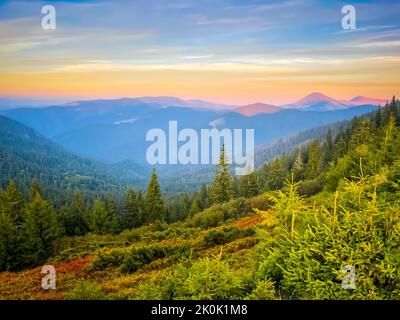 Natur Sonnenuntergang in Bergwaldlandschaft. Szenisches Bild der märchenhaften Landschaft in sonnendurchfluteten mit majestätischen Felsberg im Hintergrund. Karpaten, Ukraine. Stockfoto