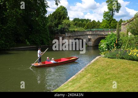 Ein Paar genießt es, an einem schönen klaren Tag auf dem Fluss Cam in der Nähe der Rückseite von King's College zu spielen. In Cambridge, England, Vereinigtes Königreich. Stockfoto