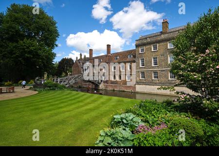 Die alte, ikonische, gewölbte, hölzerne, Fußgängerbrücke über den Fluss Cam neben einem perfekten grünen Rasen. In Cambridge, England, Vereinigtes Königreich. Stockfoto