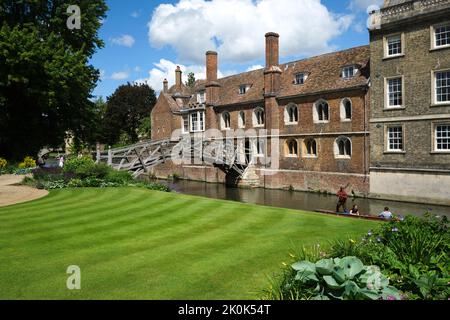 Die alte, ikonische, gewölbte, hölzerne, Fußgängerbrücke über den Fluss Cam neben einem perfekten grünen Rasen. In Cambridge, England, Vereinigtes Königreich. Stockfoto