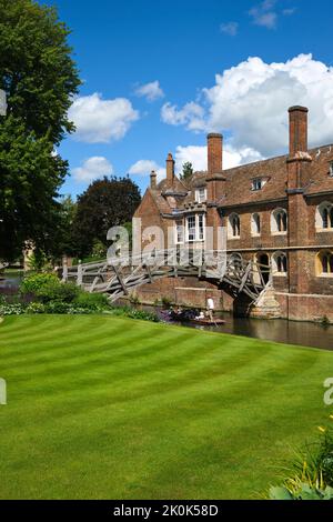 Die alte, ikonische, gewölbte, hölzerne, Fußgängerbrücke über den Fluss Cam neben einem perfekten grünen Rasen. In Cambridge, England, Vereinigtes Königreich. Stockfoto