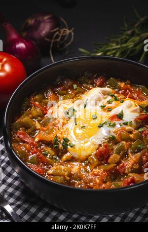 Appetitliches traditionelles spanisches Gericht aus Ei und verschiedenen Gemüsesorten, das in einer Schüssel auf dem Tisch serviert wird Stockfoto