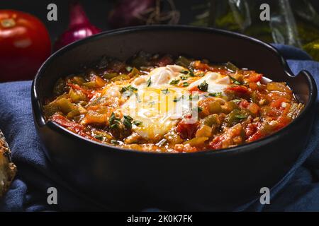 Appetitliches traditionelles spanisches Gericht aus Ei und verschiedenen Gemüsesorten, das in einer Schüssel auf dem Tisch serviert wird Stockfoto