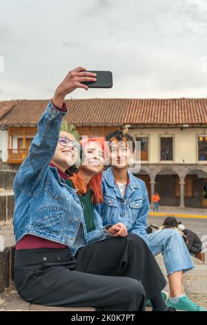Weibliche Freunde, die Selfie-Fotos auf dem Handy machen, während sie sich in der Stadt Cusco ausruhen Stockfoto