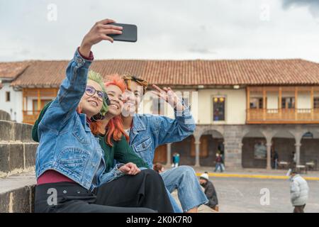 Weibliche Freunde, die Selfie-Fotos auf dem Handy machen, während sie sich in der Stadt Cusco ausruhen Stockfoto