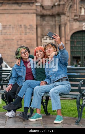 Weibliche Freunde, die Selfie-Fotos auf dem Handy machen, während sie sich in der Stadt Cusco ausruhen Stockfoto