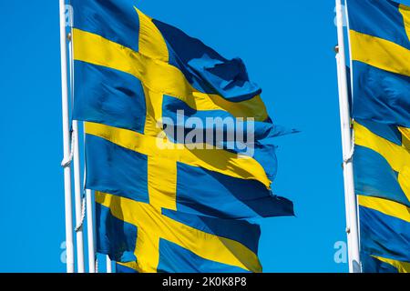 Eine Nahaufnahme der schwedischen Flaggen, die im Wind flattern Stockfoto