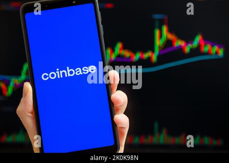 Ukraine, Odessa - Oktober, 9 2021: Coinbase mobile App läuft auf dem Smartphone-Bildschirm mit Trading Candlestick Chart im Hintergrund. Coinbase ist eine amerikanische Kryptowährungs- und Handelsplattform Stockfoto