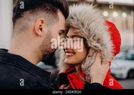 Junge attraktive Paar in Winterkleidung küssen auf einem Date Stockfoto