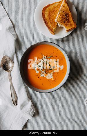 Eine Schüssel Tomatensuppe und eine Käsestie Stockfoto