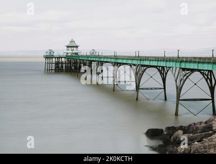 Eine lange, minimalistische Aufnahme des Clevedon Pier, die von Sir John Betjeman als der schönste Pier in England beschrieben wurde. Stockfoto