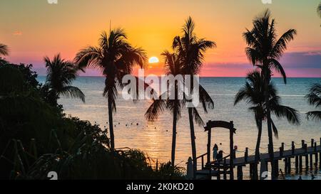 Ein lebhafter Sonnenuntergang über einem Strand in Cozumel, Mexiko Stockfoto