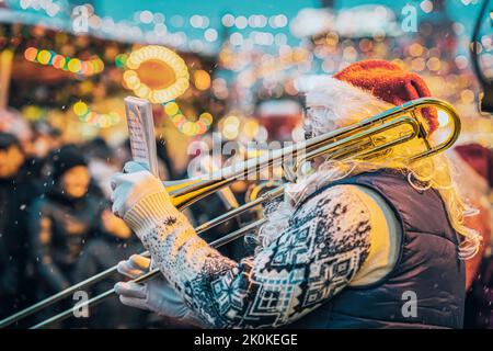 Jazzmusiker spielt Trompete im Weihnachtsmannkostüm, Weihnachtsaufführung Stockfoto