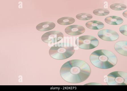 Retro-Hintergrund mit digitalen Audio-CDs auf rosa Hintergrund. Stockfoto