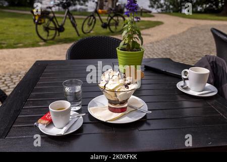 Café und Eis im Garten Café im Schloss Zirov am Zirower See in der beliebten Urlaubsregion Müritz in Mecklenburg-Vorpommern in Ostdeutschland liegt zwischen Berlin und der Ostsee. Stockfoto