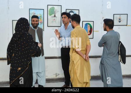 QUETTA, PAKISTAN. Sep 10-2022: Eine feministische Künstlerin aus dem Bezirk Zhob Miss Aryana Didam führt die Menschen während der Ausstellung in Quetta über ihre Kunst. Stockfoto