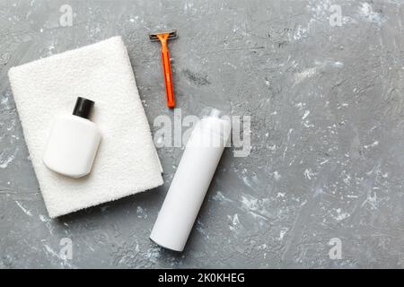 Rasierer-Set. Schermaschine, Handtuch, Lotion und Rasierschaum auf farbigem Hintergrund. Herren Bad Accessoires Draufsicht. Stockfoto