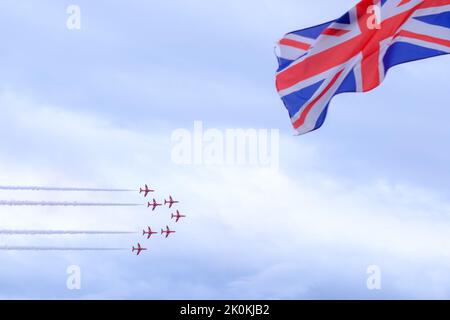 Rote Pfeile fliegen vorbei Union Jack Flag, Teignmouth Air Show, England, Großbritannien Stockfoto