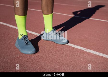 Ernte von anonymen männlichen Läufern während der Vorbereitung auf das Training im Stadion im Sommer Stockfoto