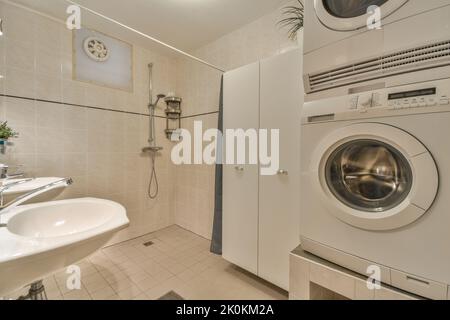 Waschbecken mit Spiegel und Dusche im modernen Badezimmer mit weiß gefliesten Wänden Stockfoto