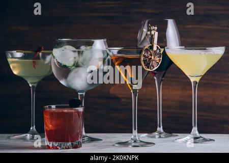 Set verschiedener moderner klassischer Alkoholcocktails in verschiedenen Gläsern auf dem Tisch Stockfoto