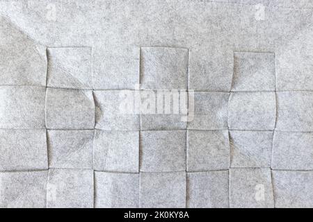 Abstrakter grauer Filzhintergrund. Aufbewahrungskorb für Zuhause aus weichem, grauem Filzmaterial. Oberfläche aus filzierter Wolle. Nahaufnahme, quadratisches Muster Stockfoto