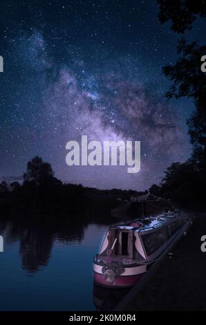 Fantasy-Nachtaufnahme auf einem Kanal mit einem festgetäuten Lastkahn Stockfoto